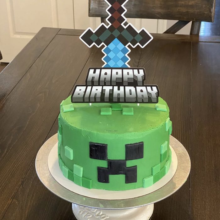 Green pixel-block video game themed birthday cake with a sword topper