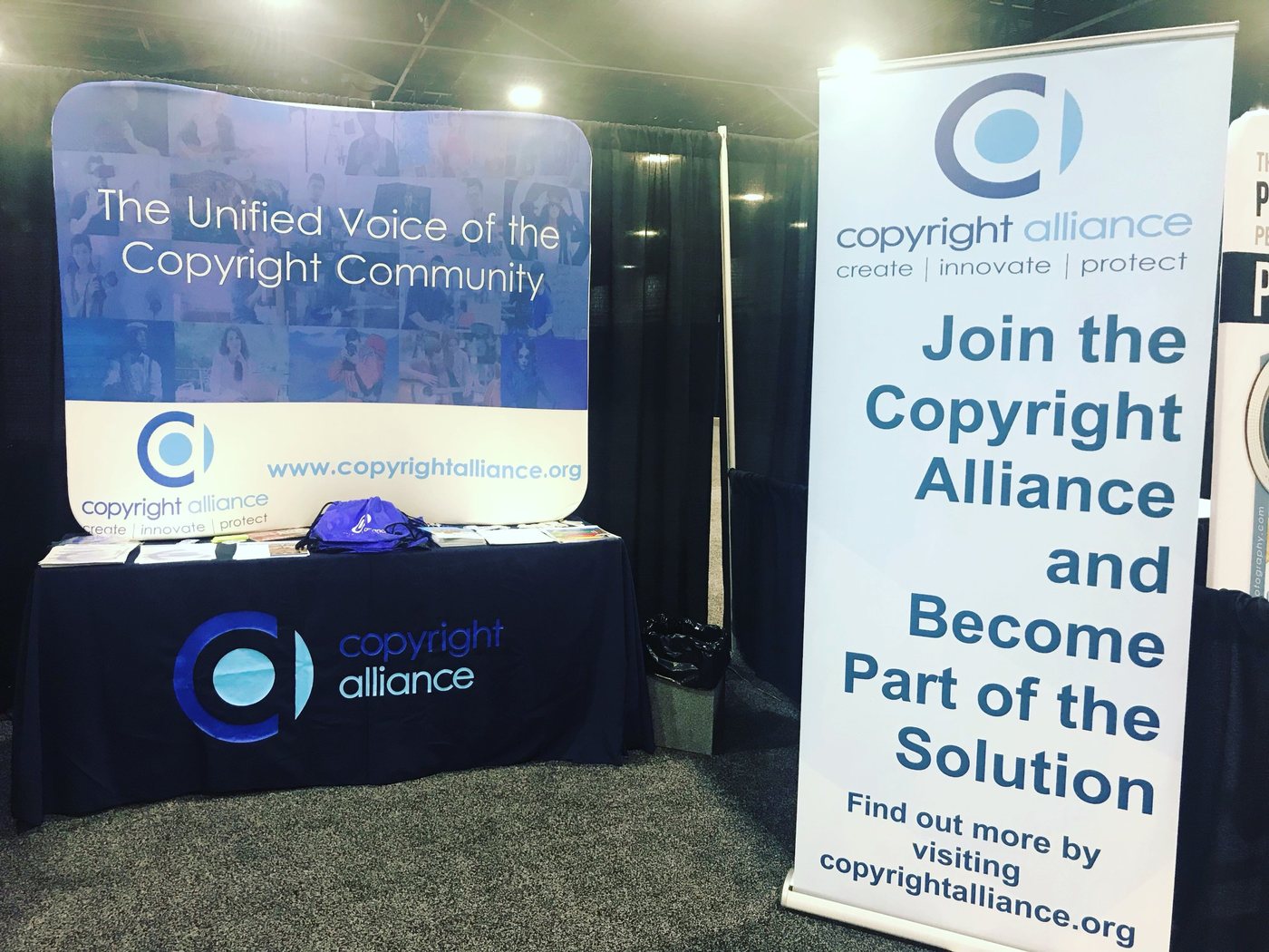Copyright Alliance exhibit booth with backdrop, branded tablecloth, and pull-up banner