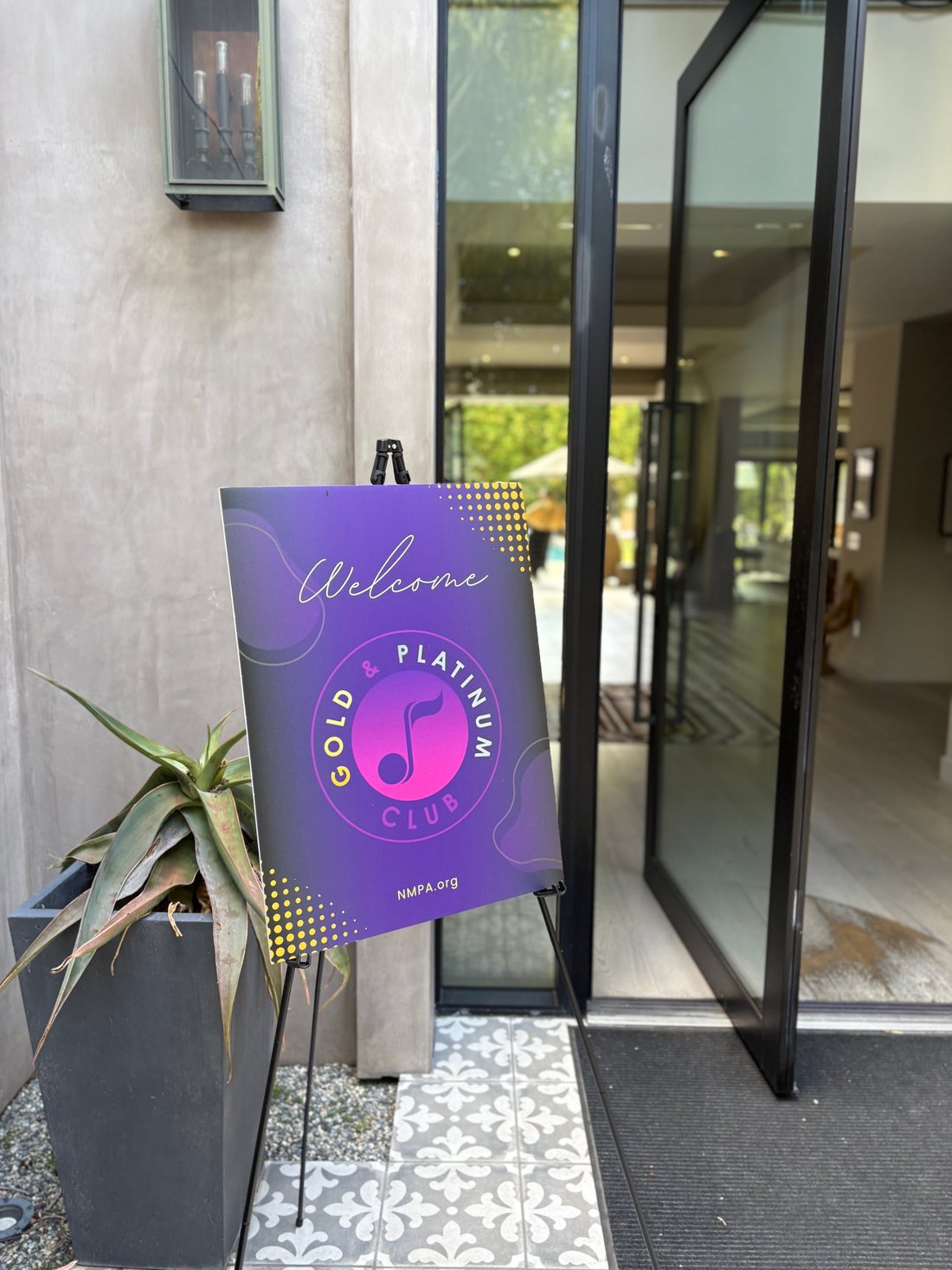 Purple Gold & Platinum Club welcome sign on an easel at an event entrance